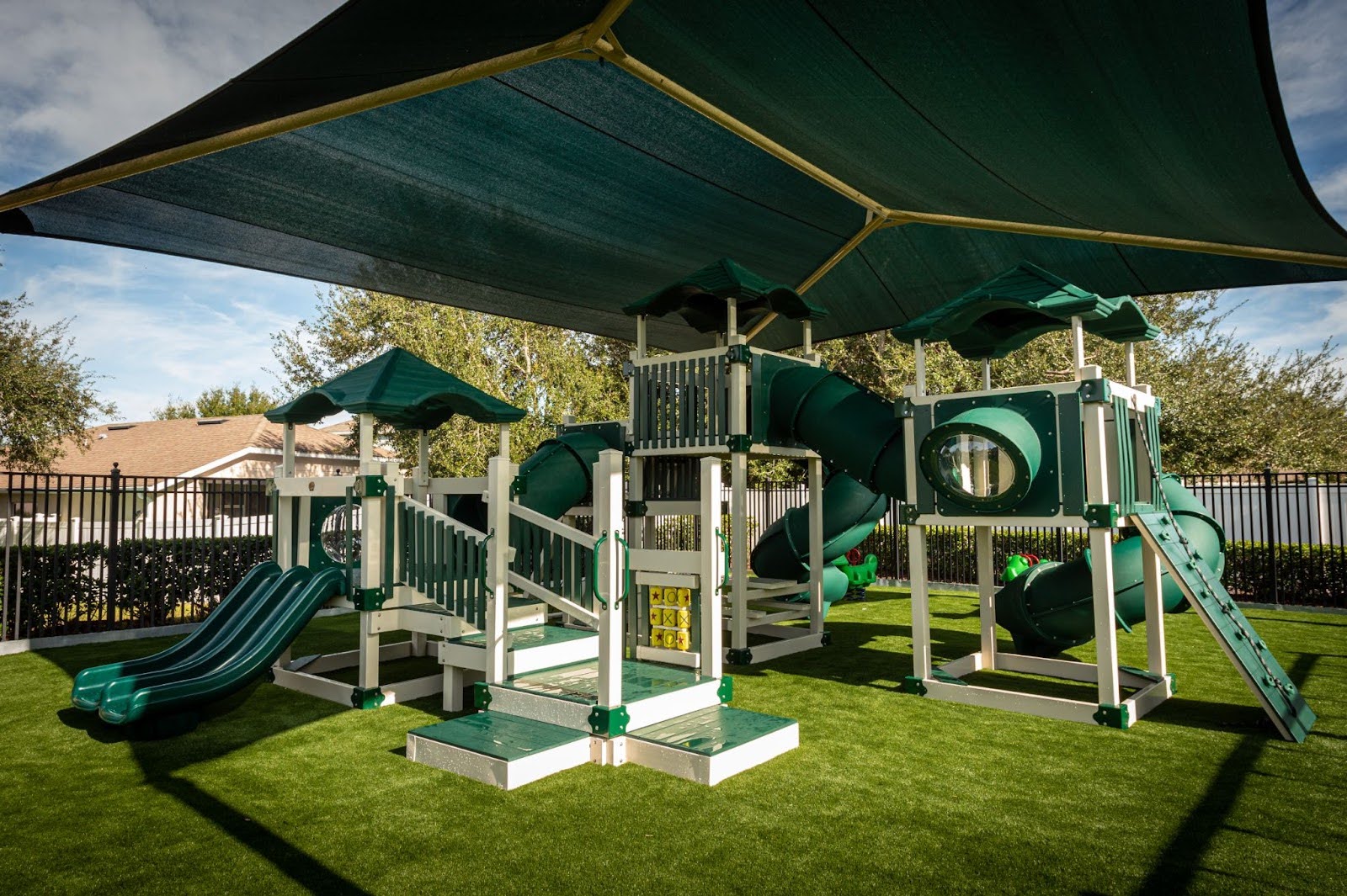 A green community swing set designed by Swing Kingdom.